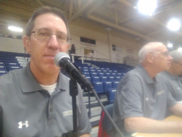 Dad announcing a basketball game  to empty bleachers.